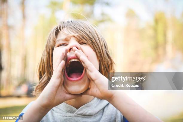 retrato del chico con la boca abierta gritando - gritar fotografías e imágenes de stock