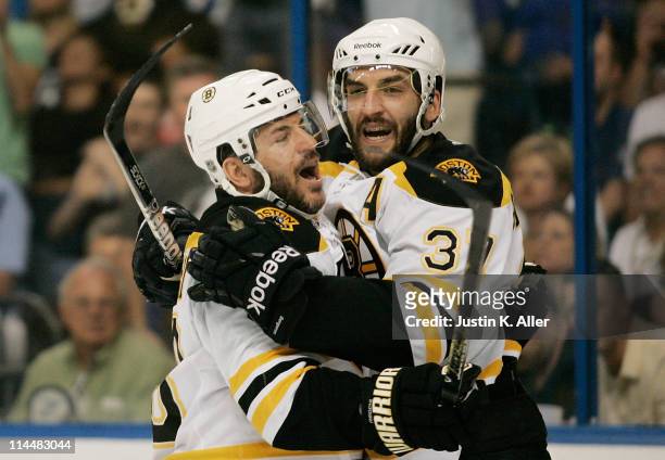 Patrice Bergeron of the Boston Bruins celebrates his first period goal against the Tampa Bay Lightning with Mark Recchi of the Boston Bruins in Game...