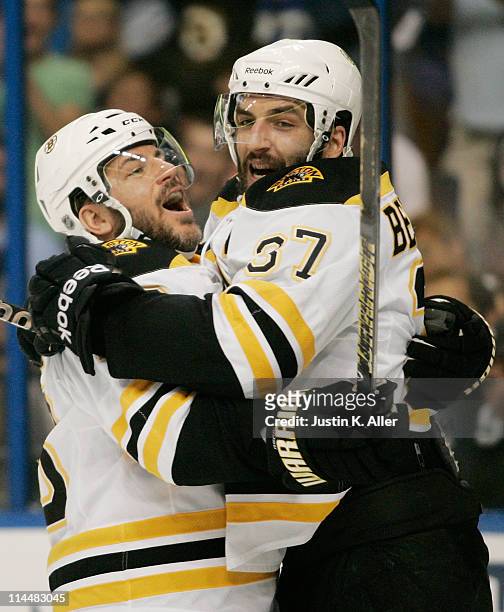 Patrice Bergeron of the Boston Bruins celebrates his first period goal against the Tampa Bay Lightning with Mark Recchi of the Boston Bruins in Game...