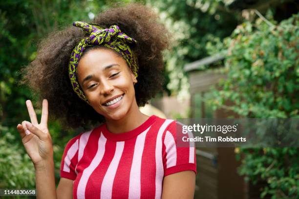 woman making peace sign - symbols of peace stock pictures, royalty-free photos & images