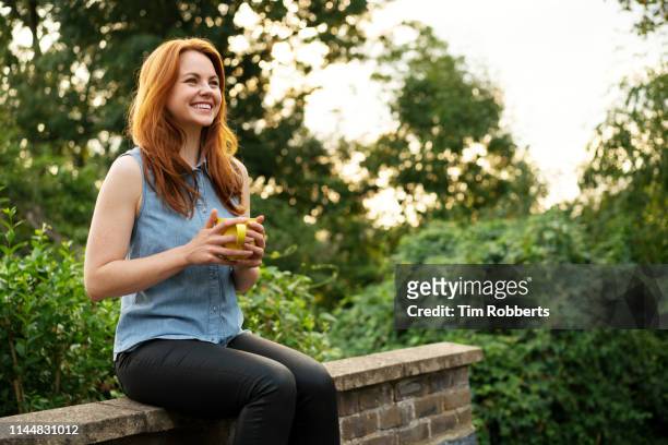woman relaxing with mug of tea - tea outdoor stock pictures, royalty-free photos & images