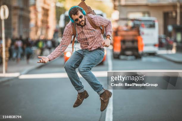 young man walking on the city road in a dancing mood - zebra crossing abstract stock pictures, royalty-free photos & images