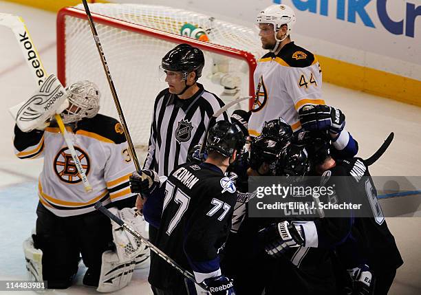 Simon Gagne of the Tampa Bay Lightning celebrates scoring a third period goal with teammates as Tim Thomas and Dennis Seidenberg of the Boston Bruins...