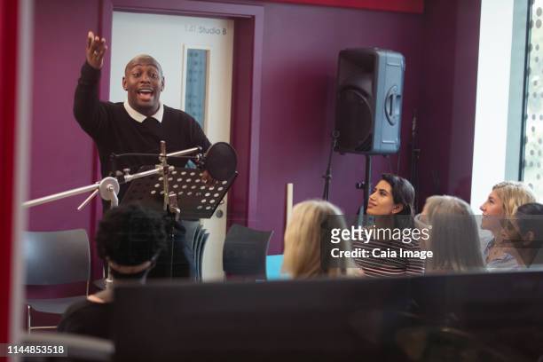 male conductor leading women singing in music recording studio - musician male energy imagens e fotografias de stock