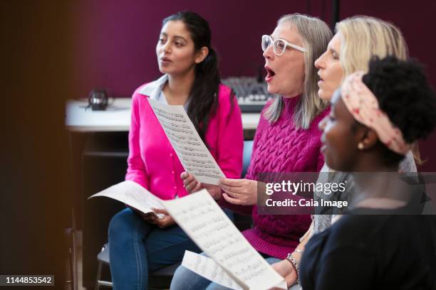 womens choir with sheet music singing in music recording studio - choir ストックフォトと画像