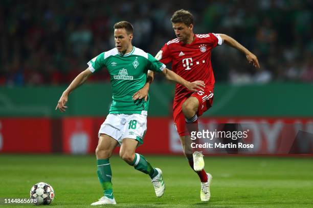 Niklas Moisander of Werder Bremen and Thomas Mueller of Bayern Munich battle for possession during the DFB Cup semi final match between Werder Bremen...