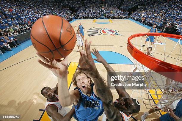 Dirk Nowitzki of the Dallas Mavericks shoots against Serge Ibaka and Kendrick Perkins of the Oklahoma City Thunder during Game Three of the Western...