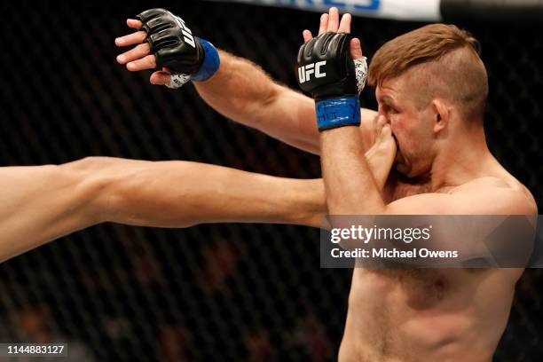 Nik Lentz absorbs a kick from Charles Oliveira of Brazil in their lightweight bout during the UFC Fight Night event at Blue Cross Arena on May 18,...