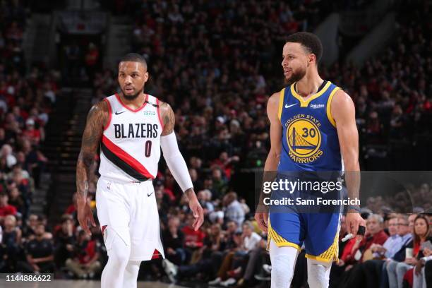 Damian Lillard of the Portland Trail Blazers and Stephen Curry of the Golden State Warriors looks on during Game Three of the Western Conference...