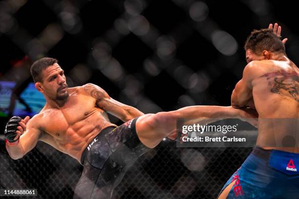 Rafael Dos Anjos throws a kick to the body against Kevin Lee during the third round of a welterweight bout at Blue Cross Arena on May 18, 2019 in...