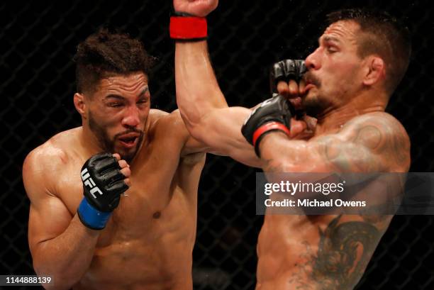 Kevin Lee punches Rafael Dos Anjos of Brazil in their welterweight bout during the UFC Fight Night event at Blue Cross Arena on May 18, 2019 in...