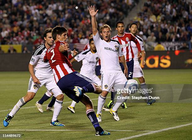 Andrew Boyens of Chivas USA shoots in front of Chris Birchall of the Los Angeles Galaxy at The Home Depot Center on May 21, 2011 in Carson,...