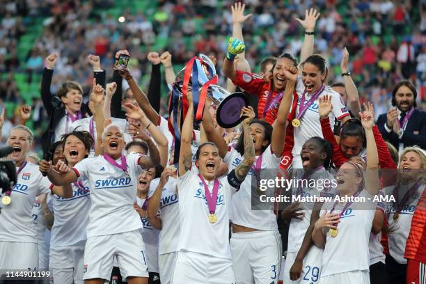 Wendie Renard of Olympique Lyonnais lifts the trophy as her team mates celebrate victory in the UEFA Women's Champions League Final between Olympique...