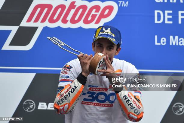 Repsol Honda Team's Spanish rider Marc Marquez kisses his trophy on the podium after winning the MotoGP race during the French Motorcycle Grand Prix...