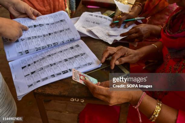 An official seen checking for the names of voters at a polling station during the final phase of India's general election in Patiala district of...