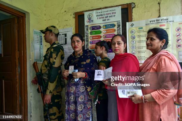 Indian women seen showing their identity cards as they queue to cast their vote at a polling station during the final phase of India's general...