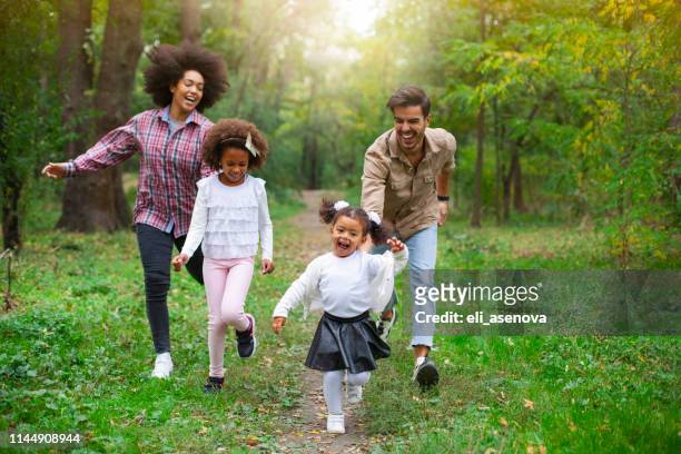 carefree family having fun while running in spring day outdoors. - following path stock pictures, royalty-free photos & images