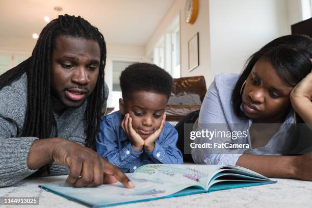 reading time with mom and dad - childhood development stock pictures, royalty-free photos & images