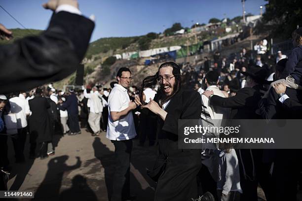 Ultra-Orthodox Jews celebrate at the grave site of Rabbi Shimon Bar Yochai in the northern Israeli village of Meron in the early hours of May 22,...