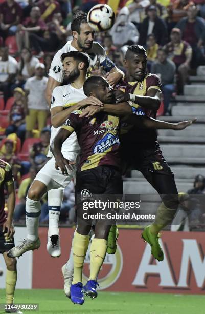 Leyvin Balanta and Sergio Mosquera of Deportes Tolima jump for the ball against Carlos Izquierdoz and Lisandro Lopez of Boca Juniors during a group G...