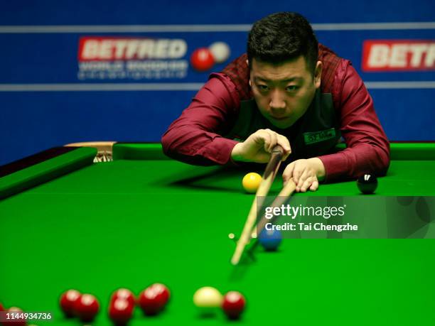 Li Hang of China plays a shot in the first round match against Barry Hawkins of England during day five of the 2019 Betfred World Snooker...