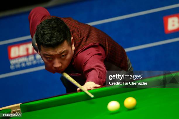 Li Hang of China plays a shot in the first round match against Barry Hawkins of England during day five of the 2019 Betfred World Snooker...