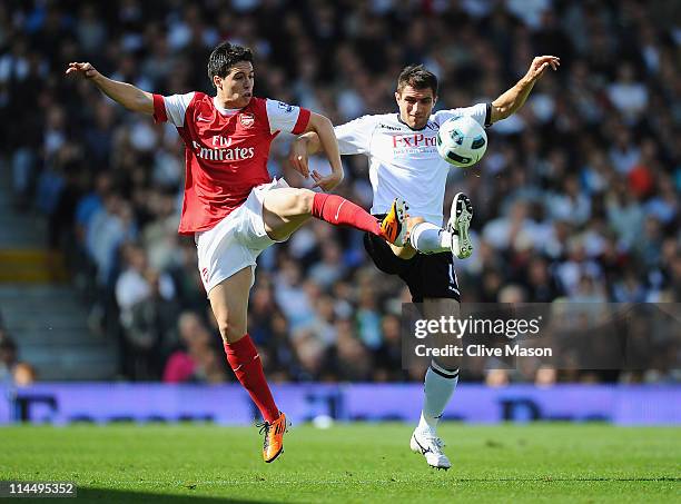 Aaron Hughes of Fulham and Samir Nasri of Arsenal compete for the ball during the Barclays Premier League match between Fulham and Arsenal at Craven...