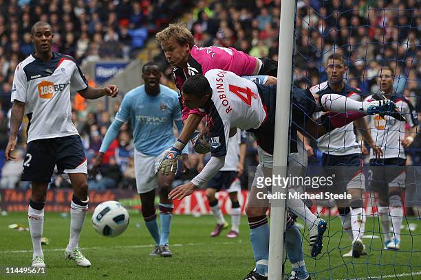 Jussi Jaaskelainen the Bolton goalkeeper clears under pressure from Yaya Toure and Paul Robinson during the Barclays Premier League match between...