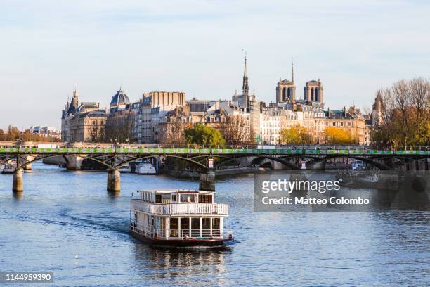 river seine with tour boat, ile de la cite, paris, france - bateau mouche stock pictures, royalty-free photos & images
