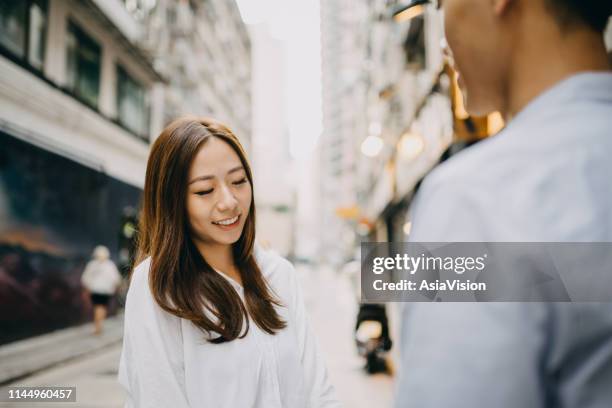 香港のシティストリートで話している笑顔の若いカップル - 初めての出来事 ストックフォトと画像