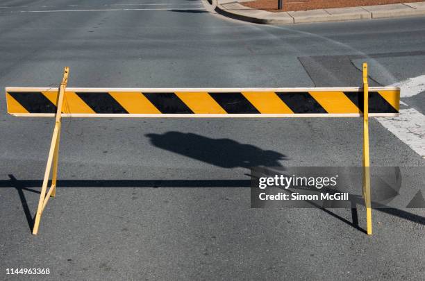 yellow and black striped road traffic barricade on a suburban road - barricada divisa - fotografias e filmes do acervo