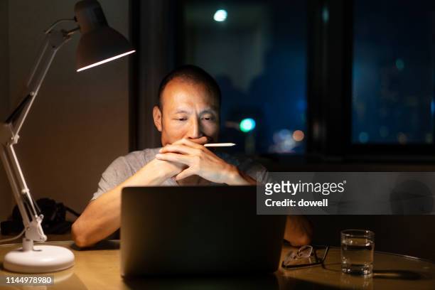 chinese man working overtime at night - working overtime stock pictures, royalty-free photos & images