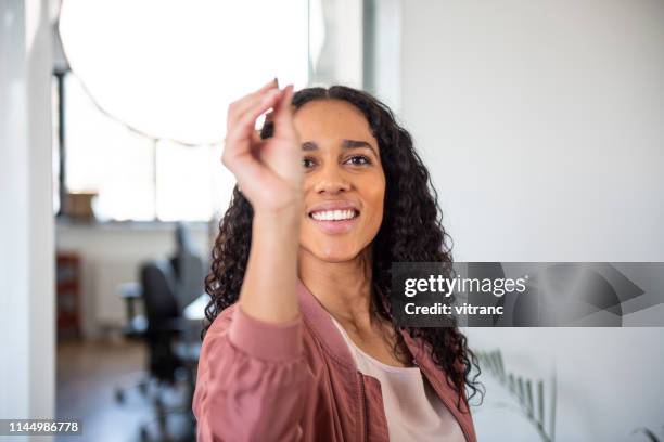 young happy woman playing darts in office - pub darts stock pictures, royalty-free photos & images