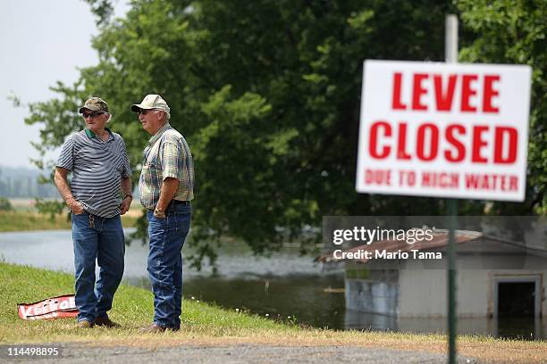 People stand on a closed levee along the Yazoo River near Yazoo City May 22, 2011 in Yazoo County, Mississippi. The Yazoo River floodwaters are...