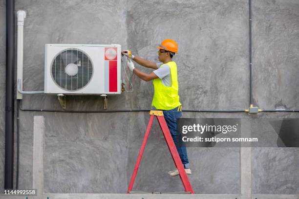 air condition technician service checking air conditioner on the wall building - hvac repair stock pictures, royalty-free photos & images