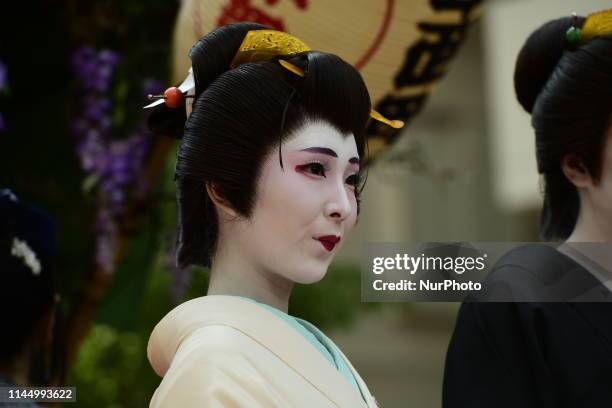 Woman in kimono pose for a photograph in the street of Asakusa during Sanja festival on May 19, 2019 in Tokyo, Japan. A boisterous traditional...