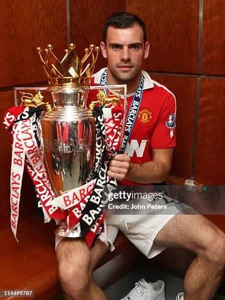 Darron Gibson of Manchester United poses in the dressing room with the Barclays Premier League trophy after the Barclays Premier League match between...