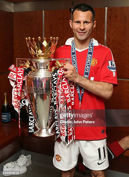 Ryan Giggs of Manchester United poses in the dressing room with the Barclays Premier League trophy after the Barclays Premier League match between...