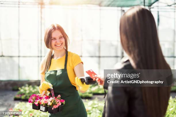 växthus arbetare som säljer pottered blommor. kontaktlös kort betalning. - card payment bildbanksfoton och bilder