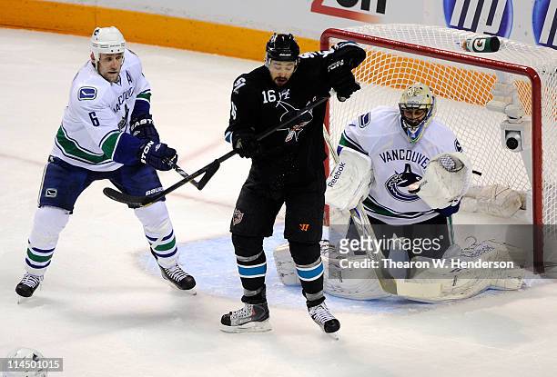 Devin Setoguchi of the San Jose Sharks deflects the puck on net as Sami Salo and goaltender Roberto Luongo of the Vancouver Canucks defend the play...