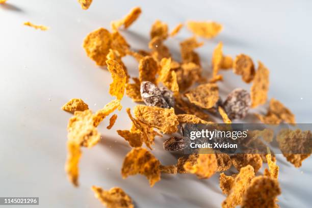 raisin wheat bran cereal taken in high speed"n - bran stock pictures, royalty-free photos & images