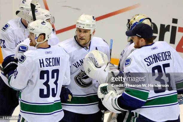 Henrik Sedin, Sami Salo and back-up goaltender Cory Schneider of the Vancouver Canucks congratulate on another after they defeated the San Jose...