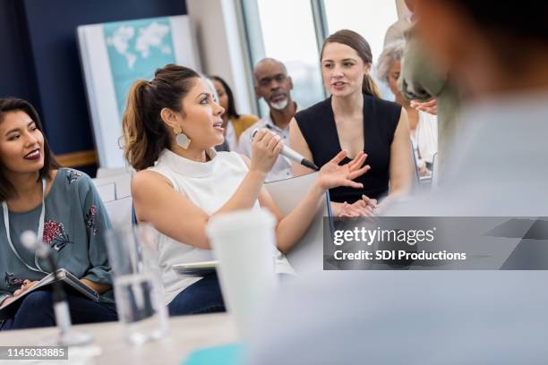 neugierige frau stellt während der betriebskonferenz fragen - podiumsdiskussion stock-fotos und bilder