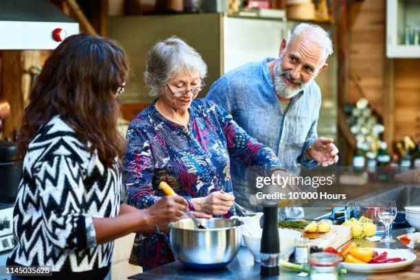 senior woman making dinner with friends - doing a favor stock pictures, royalty-free photos & images