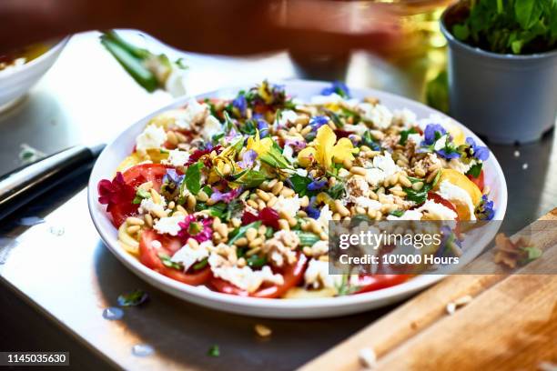 beautiful fresh salad dressed with flower petals - serving dish foto e immagini stock