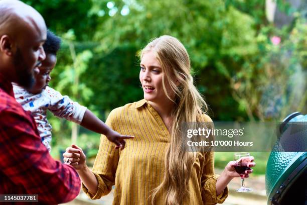 mid adult woman holding wine talking to man with son - blended family stockfoto's en -beelden