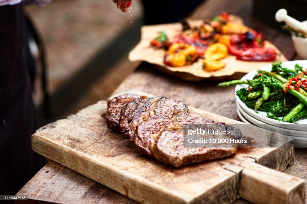 Freshly cooked steak on wooden board with salt flakes