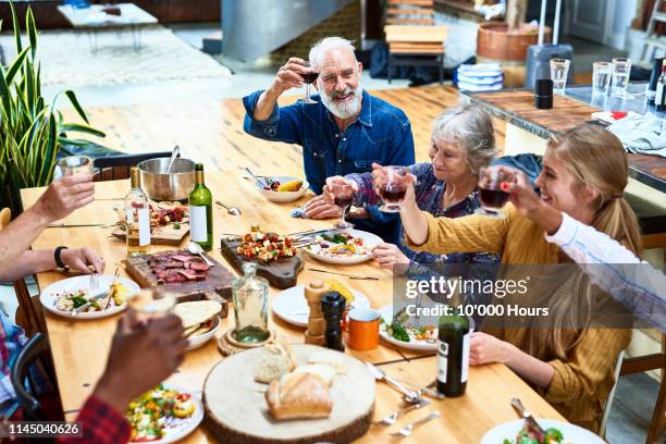 high angle view of family enjoying meal together at home - hythe stock-fotos und bilder