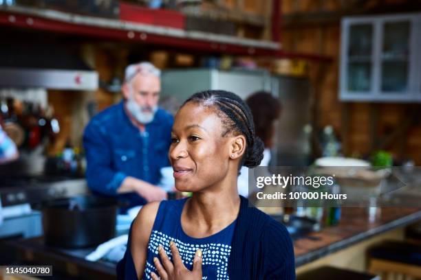 attractive woman with braided hair smiling with hand on chest - humility stockfoto's en -beelden