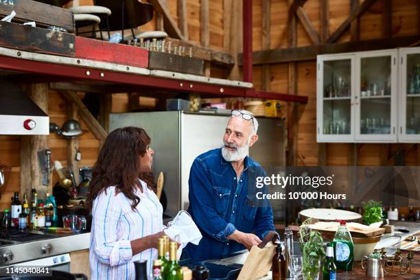 mature couple talking in kitchen and doing the dishes - middle aged couple cooking ストックフォトと画像